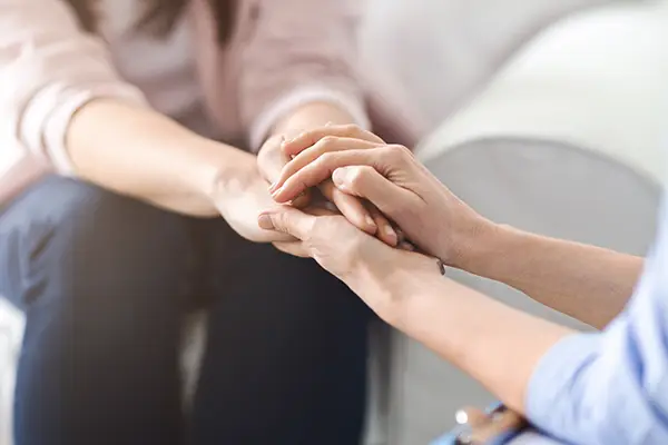 Image of a mental health treatment counselor extending their hands to offer support.